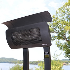 A black portable propane heater with a view of the lake and trees in the background