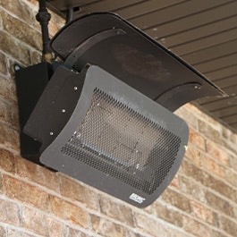 A radiant propane heater attached to a brick wall