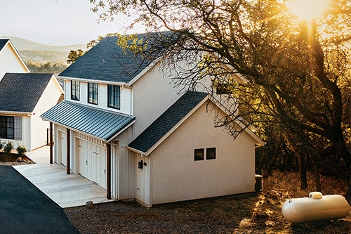 A modern white home with a discreet propane tank